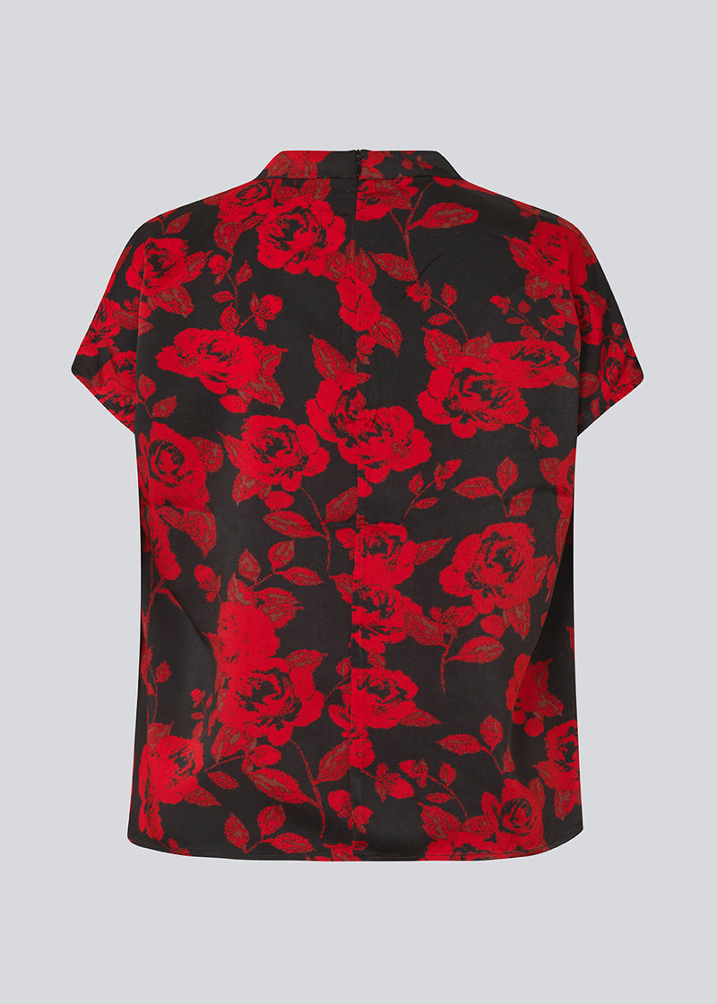 Kortærmet top i et smukt rosenprint. Ruthiemd print SS top har høj hals, skjult lynlår i ryggen og er lavet i genanvendt polyester - en klassisk og elegant style