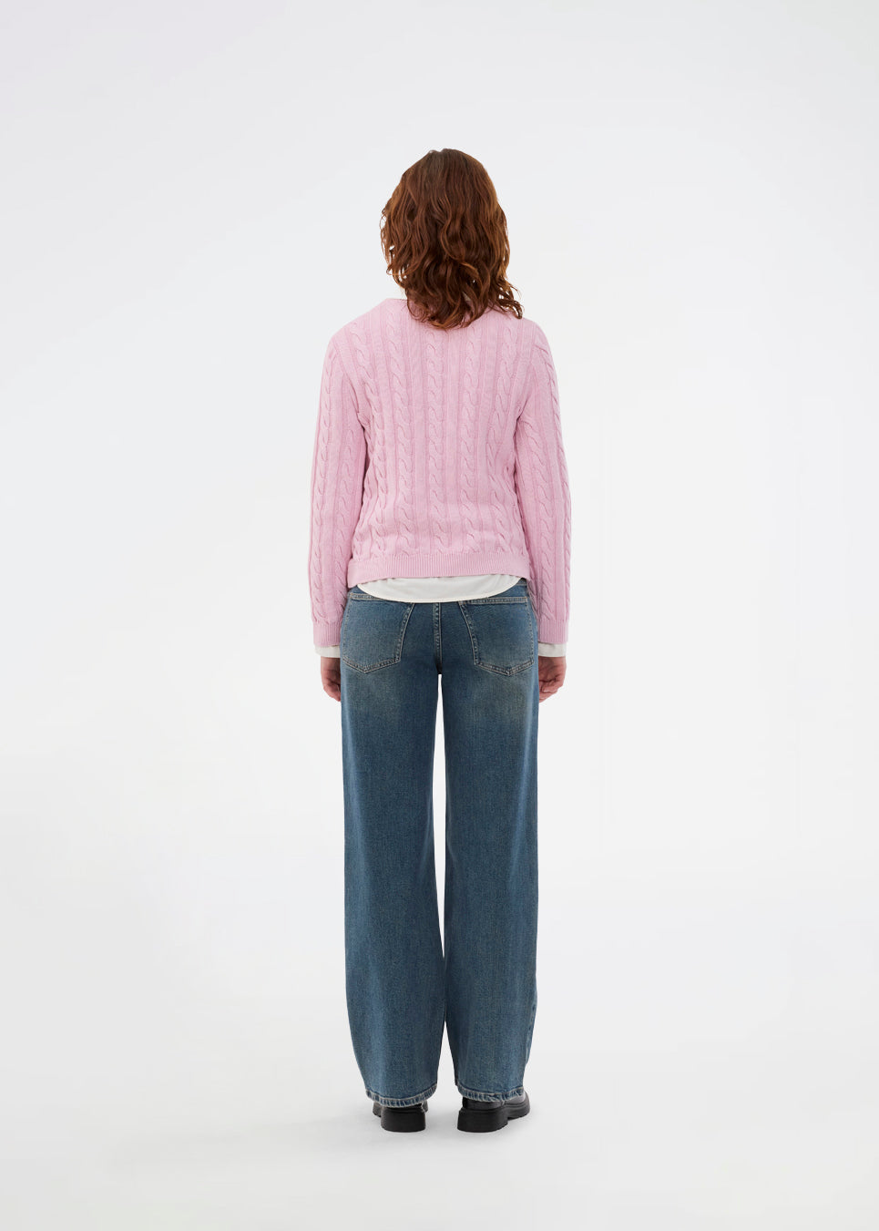 Tætsiddende strik i lyserød med rund hals i 100% økologisk bomuld. Sabremd o-neck er lavet i kabelstrik og har et broderet brystlogo. Modellen er 175 cm og har en str s/36 på.