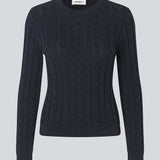 Tætsiddende strik med rund hals i 100% økologisk bomuld. Sabremd o-neck er lavet i kabelstrik og har et broderet brystlogo. Modellen er 175 cm og har en str s/36 på.