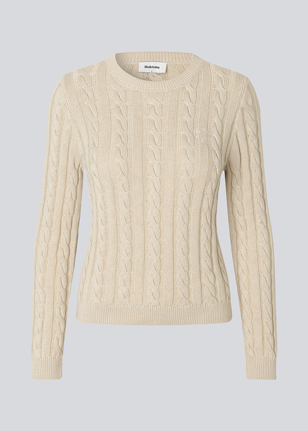 Tætsiddende strik med rund hals i 100% økologisk bomuld. Sabremd o-neck er lavet i kabelstrik og har et broderet brystlogo. Modellen er 175 cm og har en str s/36 på.