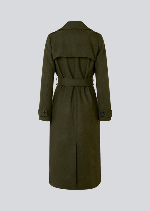 Klassisk, dobbeltradet uldfrakke i mørkegrøn med krave og revers. ShayMD coat har bredt taljebælte, skulderstropper, brede manchetter og stormflap. Med for og slids bagpå.