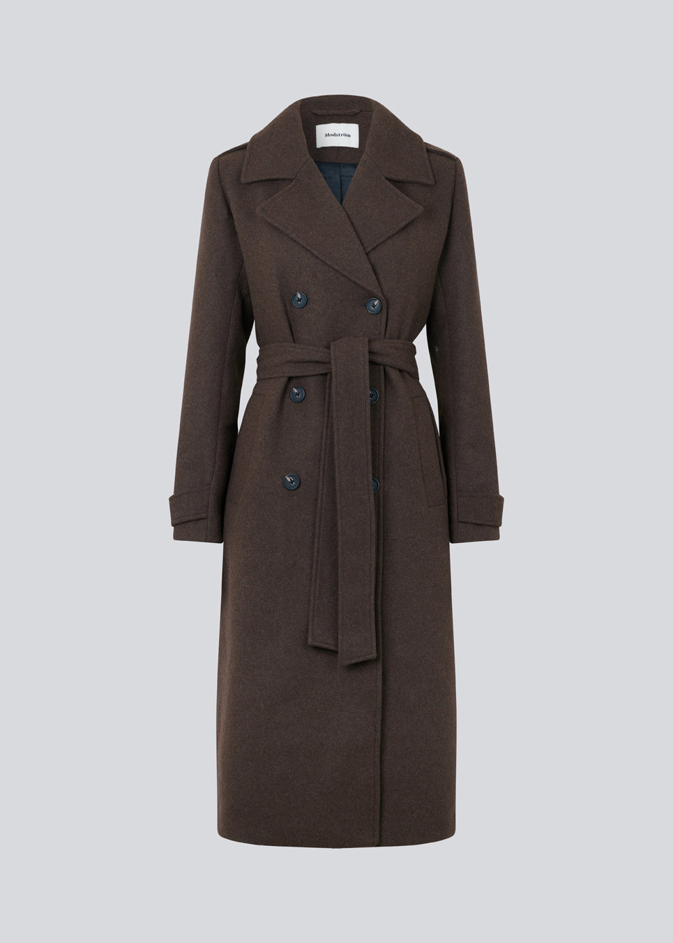 Brun klassisk, dobbeltradet uldfrakke med krave og revers. ShayMD coat, i farven Dark Coffee, har bredt taljebælte, skulderstropper, brede manchetter og stormflap. Med for og slids bagpå.