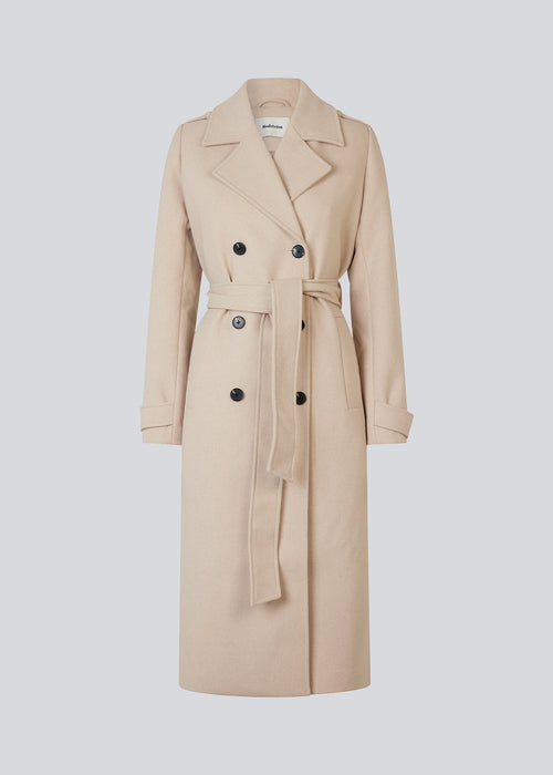 Klassisk, dobbeltradet uldfrakke i lys beige med krave og revers. ShayMD coat har bredt taljebælte, skulderstropper, brede manchetter og stormflap. Med for og slids bagpå.