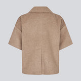 Kortærmet cape-jakke i blød uldblanding i beige/lys brun. Siljamd cape har en krave, lommer og fine brune knapper. Perfekt lag-på-lag-stykke over en strik for et elegant, sæsonrigtigt look.&nbsp;