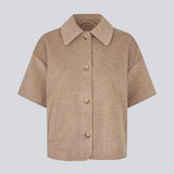 Kortærmet cape-jakke i blød uldblanding i beige/lys brun. Siljamd cape har en krave, lommer og fine brune knapper. Perfekt lag-på-lag-stykke over en strik for et elegant, sæsonrigtigt look.&nbsp;