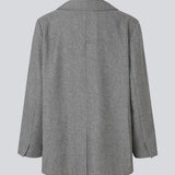 Grå blazer i uldblanding. Simonmd blazer har krave, lange ærmer og to rummelige lommer. Den lukkes med en enkel, synlig knap og er perfekt som overgangsjakke eller som et varmt lag over en t-shirt i vintermånederne.