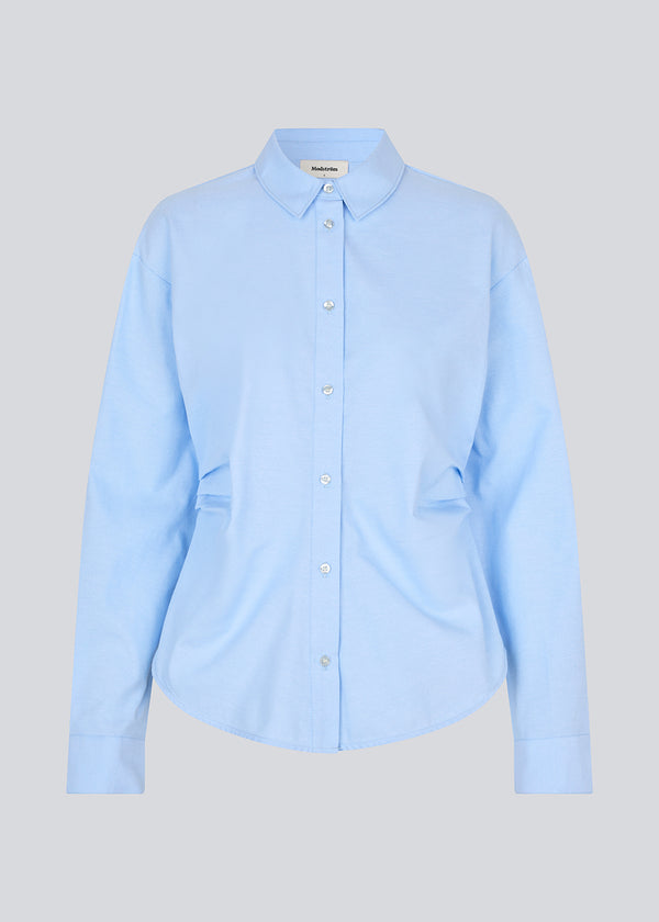 Klassisk figursyet skjorte. Siobanmd shirt har rynkedetaljer i siden, lange ærmer og knaplukning – elegant og alsidig.
