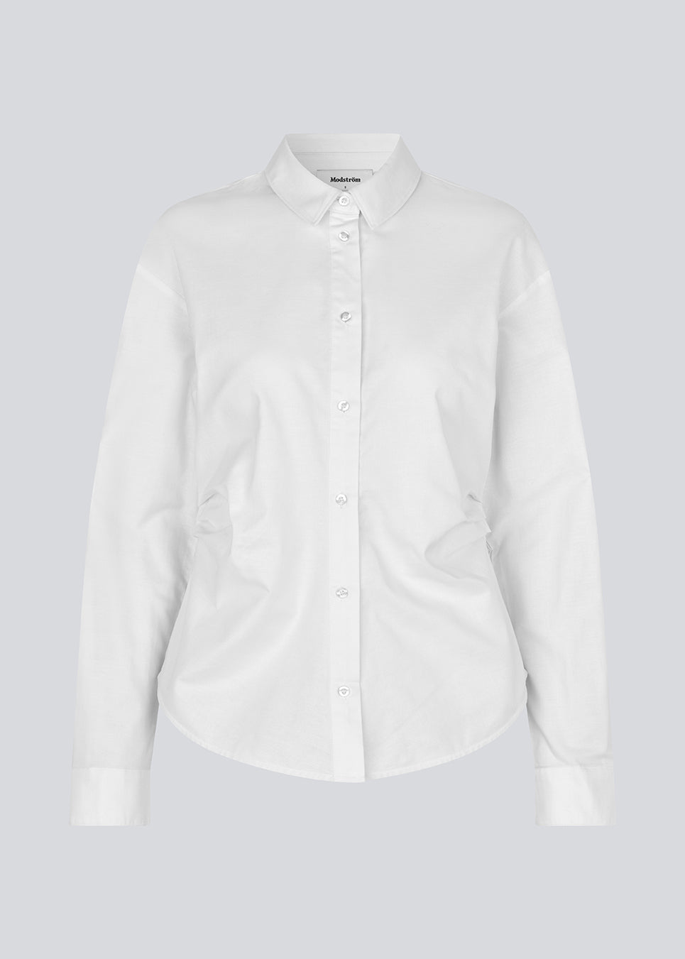 Moderne hvid skjorte med fiminint udtryk. Siobanmd shirt har klassiske detaljer som krave, knappelukning og lange ærmer. Rynkesyninger i taljen skaber en smuk, feminin silhuet. Fremstillet i 58 % økologisk bomuld.