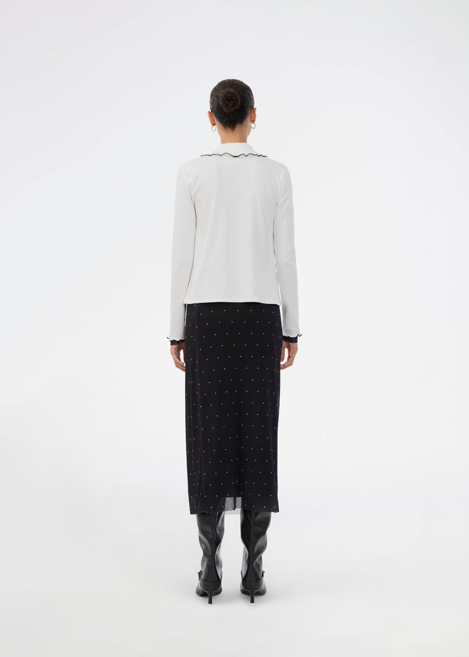 Figursyet sort midinederdel i mesh med hvide prikker og underskørt. Samalamd Print Skirt er lavet i 92% genanvendt polyester og kombinerer strækbarhed med komfort.