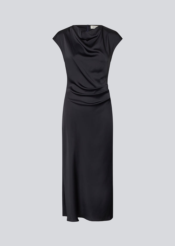 Lang ærmeløs kjole i mørkeblå med rynkedetalje i satin. TailorMD dress har en høj hals, usynlig lynlås i ryggen og en slids i siden.