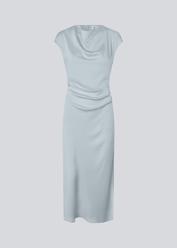 Lang ærmeløs kjole i smuk lyseblå med rynkedetalje i satin. TailorMD dress har en høj hals, usynlig lynlås i ryggen og en slids i siden.&nbsp;