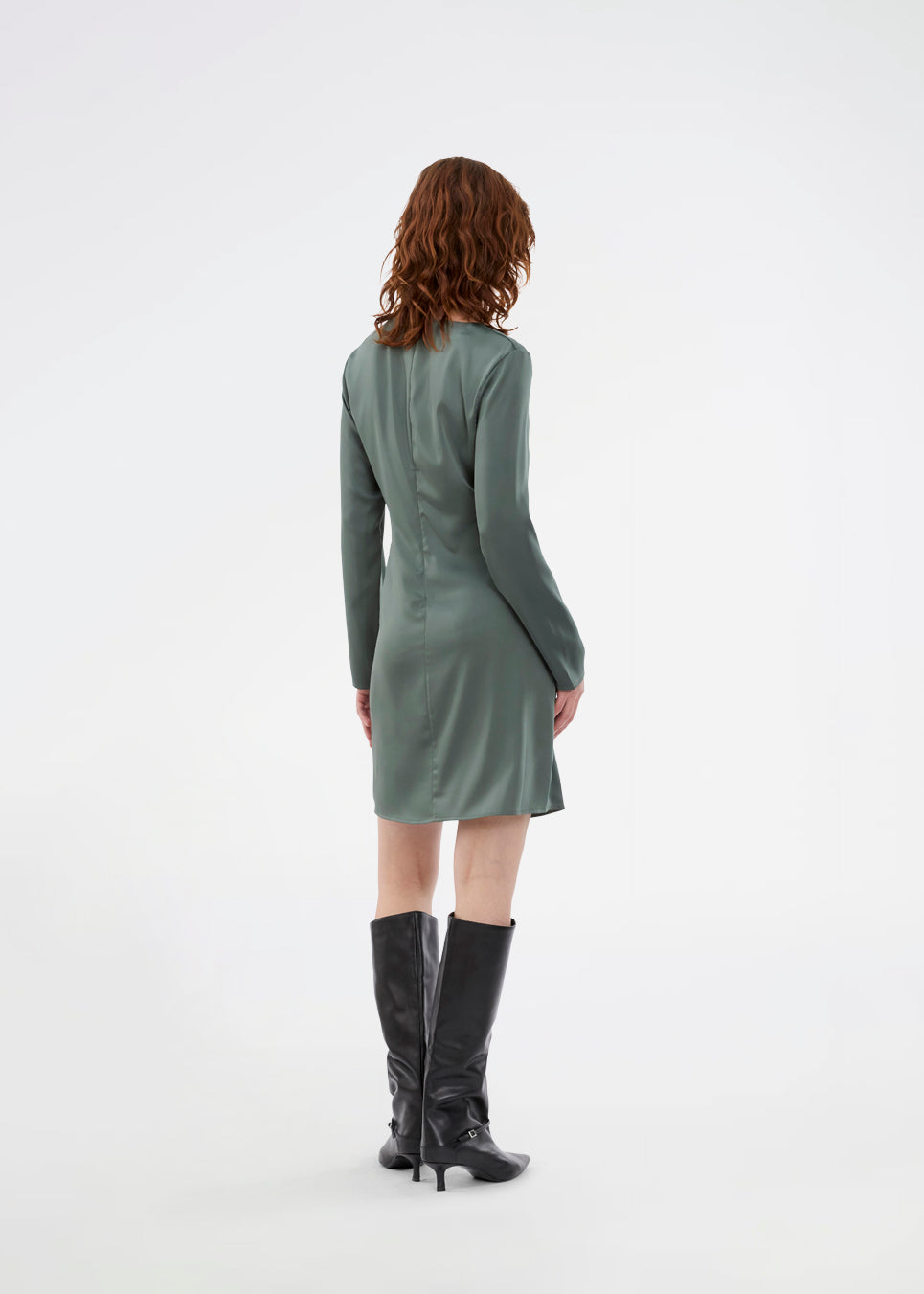 Kort kjole i grøn i en smuk satin med flatterende rynkedetalje i siden og halsudskæring med let vandfald. TailorMD dress har lange ærmer og usynlig lynlås i ryggen.
