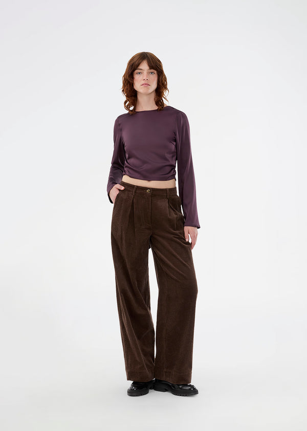 Langærmet top i satin. TailotMD top &nbsp;har en flatterende åben ryg og bindebånd, der giver den et elegant og feminint udtryk. Modellen er 177 cm og har en str S/36 på.
