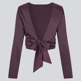 Langærmet top i satin. TailotMD top &nbsp;har en flatterende åben ryg og bindebånd, der giver den et elegant og feminint udtryk. Modellen er 177 cm og har en str S/36 på.