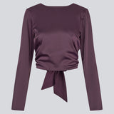 Langærmet top i satin. TailotMD top &nbsp;har en flatterende åben ryg og bindebånd, der giver den et elegant og feminint udtryk. Modellen er 177 cm og har en str S/36 på.