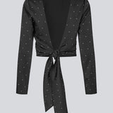 Langærmet top i satin i sort med hvide små prikker. Tailormd print LS top har en flatterende åben ryg og bindebånd, der giver den et elegant og feminint udtryk. Modellen er 177 cm og har en str S/36 på.
