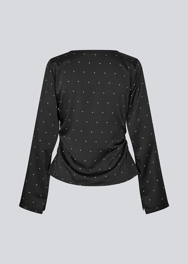 Sort ærmeløs top i satin. TailotMD print top &nbsp;har en flatterende åben ryg og bindebånd, der giver den et elegant og feminint udtryk.