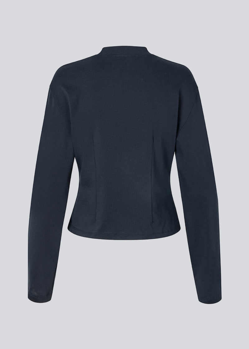 Let cropped langærmet t-shirt i mørkeblå i 100% økologisk bomuld. Tampamd LS t-shirt har en rund hals, lange ærmer og er figursyet.
