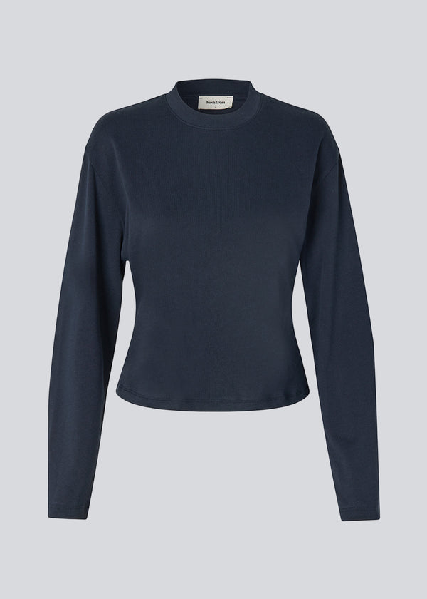 Let cropped langærmet t-shirt i mørkeblå i 100% økologisk bomuld. Tampamd LS t-shirt har en rund hals, lange ærmer og er figursyet.