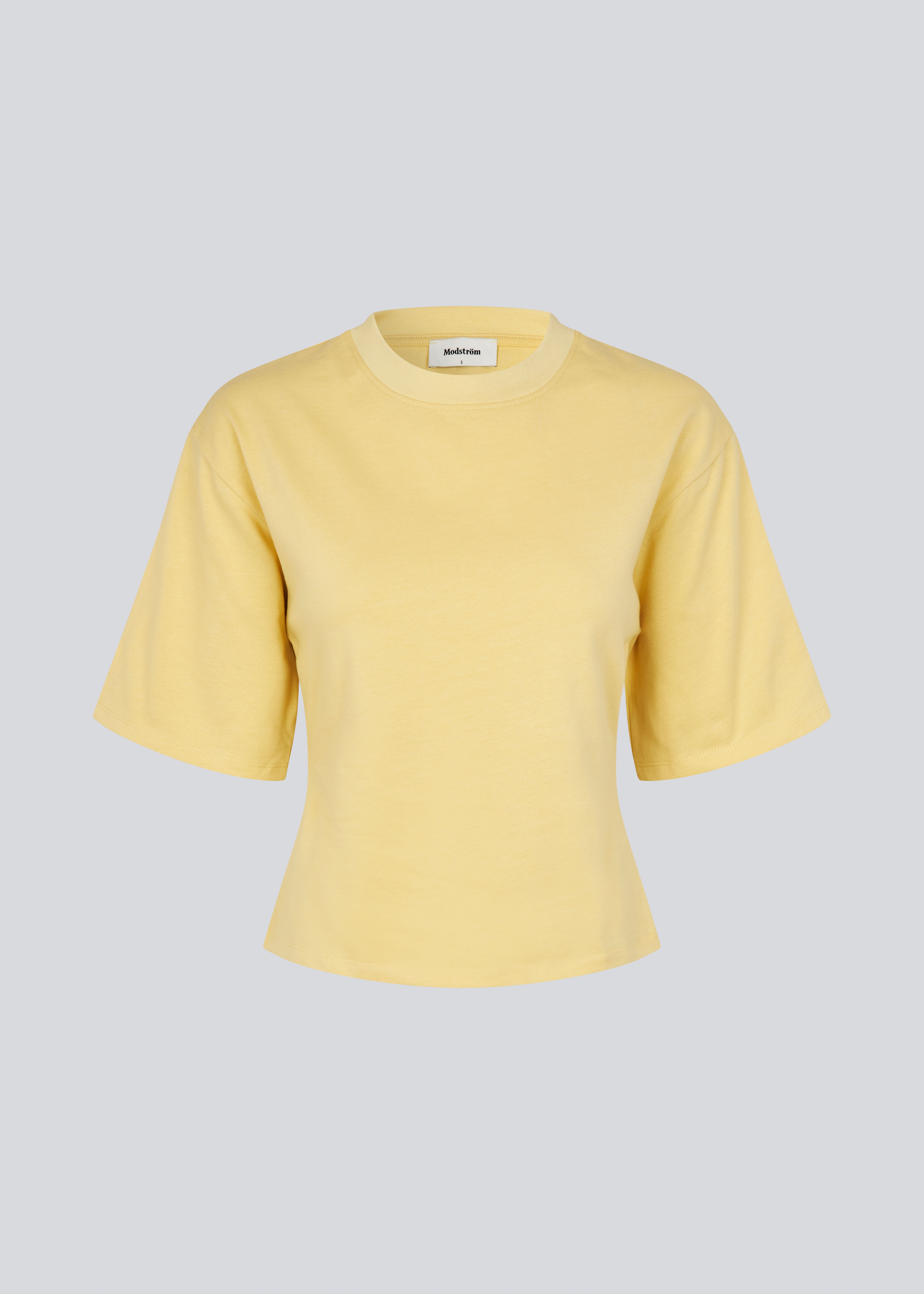 Let cropped gul t-shirt i 100% økologisk bomuld. Tampamd t-shirt har en rund hals og er figursyet.