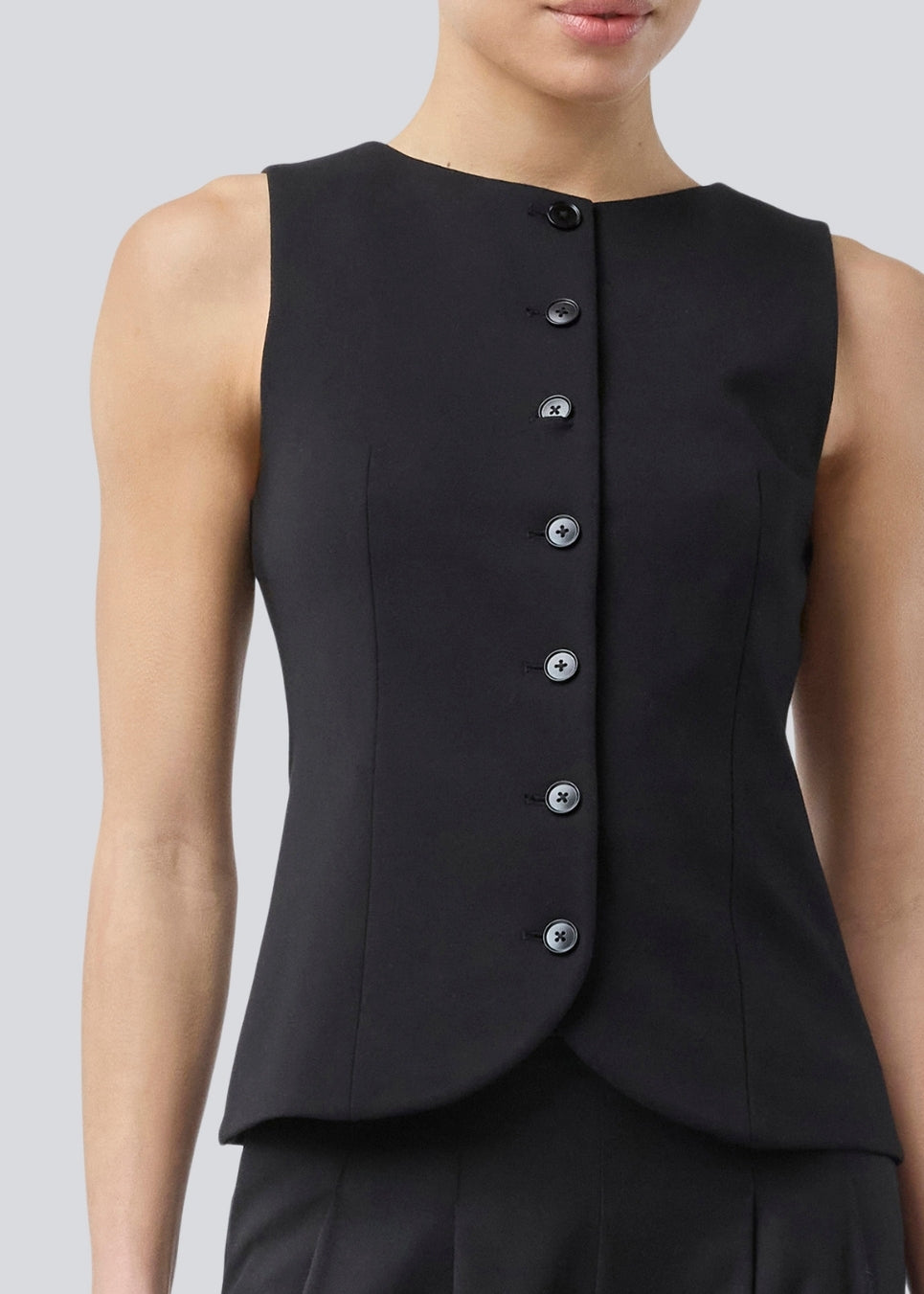 Ærmeløs sort top/vest med knappelukning i jersey. Tannymd &nbsp;top er figursyet og har en rund hals. materiale skaber en perfekt pasform. Modellen er 175 cm og har en str S/36 &nbsp;på.