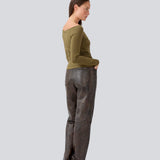 Tansy LS top i mørkegrøn har et enkelt udtryk med en bred halsudskæring og lange, smalle ærmer. Toppen har en tætsiddende pasform. Modellen er 173 cm og har en størrelse S/36 på.