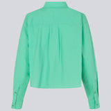 Skjorte i farven Calm Jade i økologisk bomuldspoplin med cropped længde. TapirMD cropped shirt har krave og knapper foran, samt brystlomme. Lav skuldersøm og lange ærmer med manchet og knap. Broderet logo foran. Modellen er 177 cm og har en størrelse S/36 på.