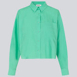 Skjorte i farven Calm Jade i økologisk bomuldspoplin med cropped længde. TapirMD cropped shirt har krave og knapper foran, samt brystlomme. Lav skuldersøm og lange ærmer med manchet og knap. Broderet logo foran. Modellen er 177 cm og har en størrelse S/36 på.