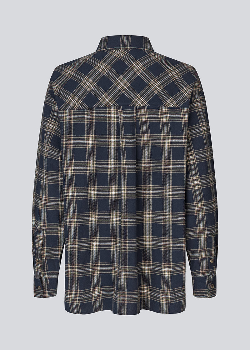 Klassisk oversize skjorte i flannel i mørkeblå tern. TappoMD shirt har en brystlomme knappe lukning fortil og manchet med knappelukning.