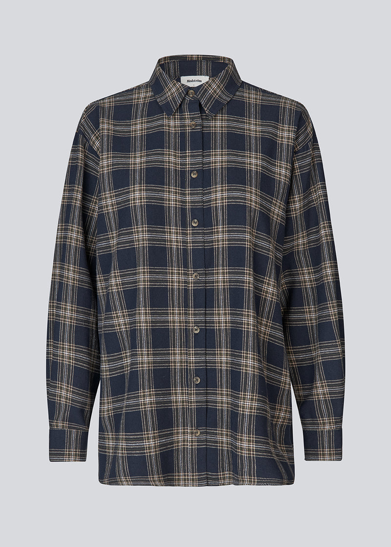 Klassisk oversize skjorte i flannel i mørkeblå tern. TappoMD shirt har en brystlomme knappe lukning fortil og manchet med knappelukning.