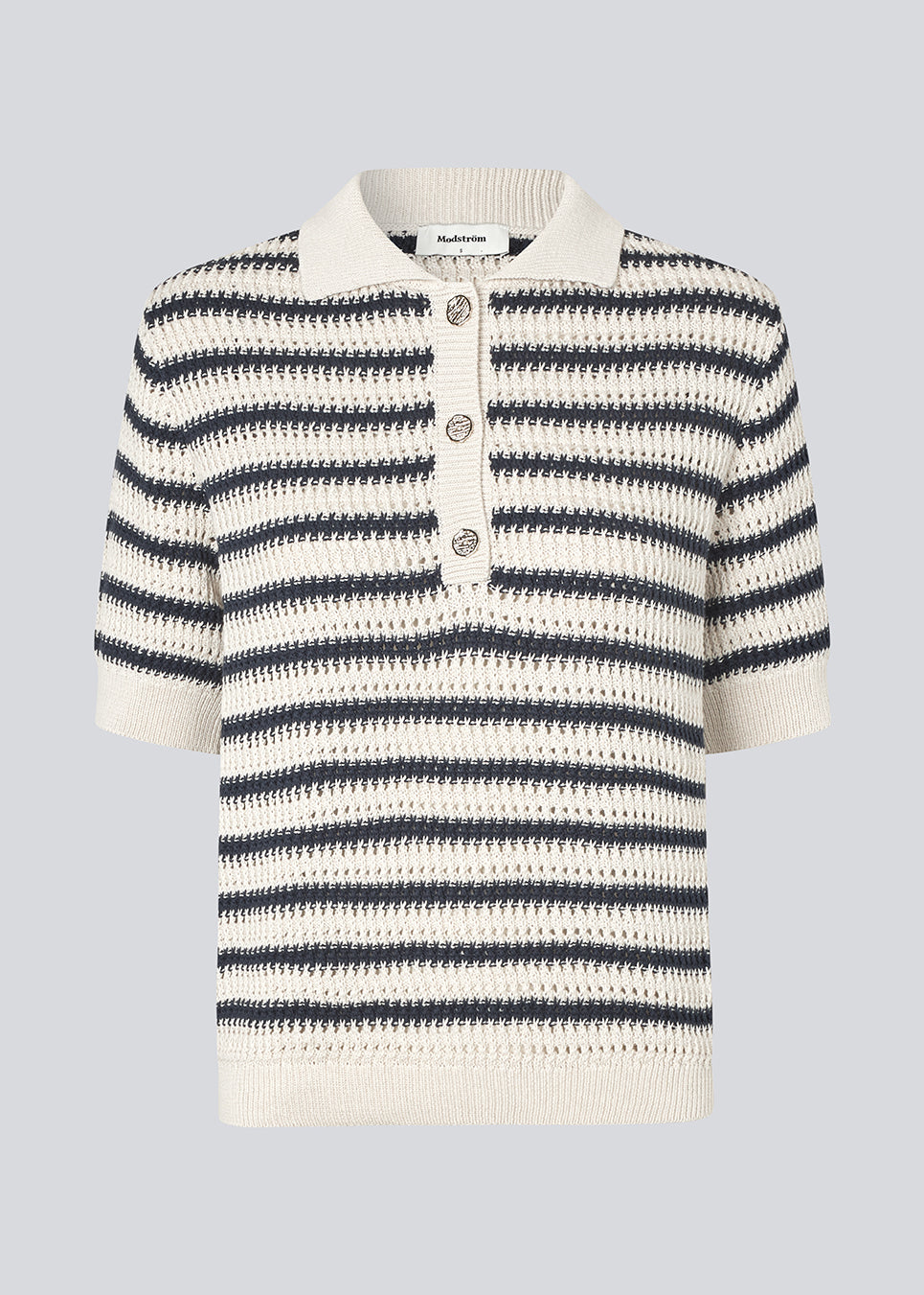 Strikket polo med korte ærmer i 100% økologisk bomuld. ToniaMD SS polo har en stolpe lukning med 3 guld knapper i metal.