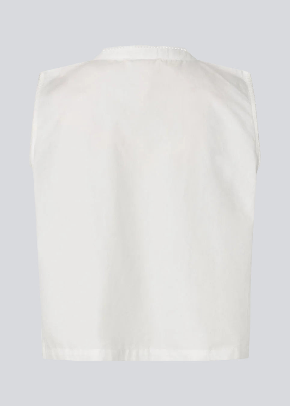Ærmeløs top i en blød bomuldskvalitet. Tessamd top har bindelukning foran, fine kantdetaljer og en enkel, afslappet silhuet. Et let og alsidigt design, der kombinerer feminine detaljer med et moderne, minimalistisk udtryk.