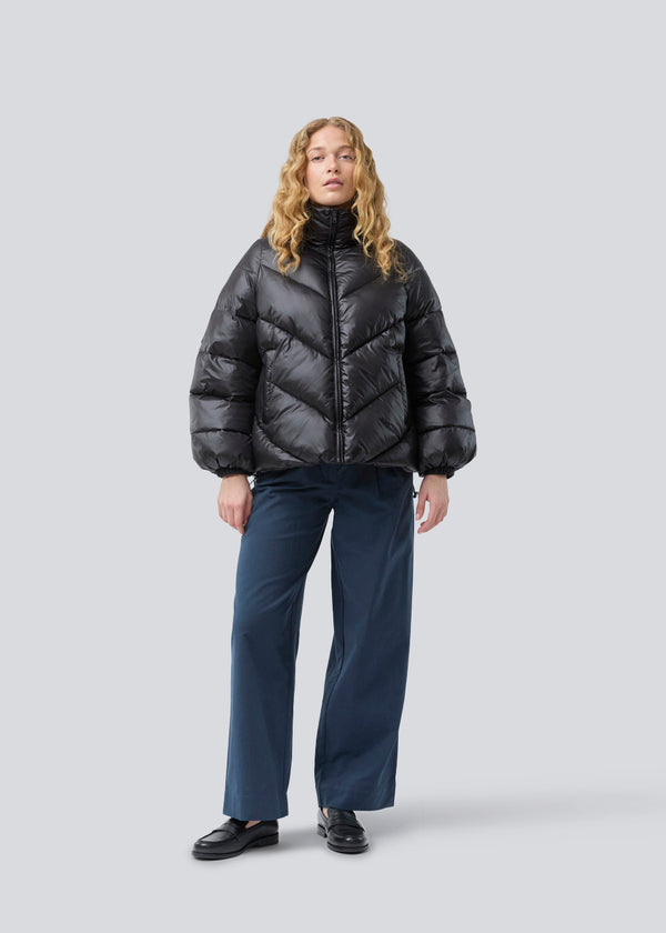 Dunjakke med høj hals i 100% genanvendt polyester. Tetrismd jacket har en lynlåslukning og en justerbar elastik i ærmet. Modellen er 175 cm og har en str. s/36 på.