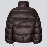 Varm pufferjakke i mørkebrun med høj hals i 100% genanvendt polyester. Tetrismd jacket har en lynlåslukning og en justerbar elastik i ærmet og bunden. Perfekt til vinterens kolde vejr i sæsonens mest efterspurgte farve.&nbsp;. ligner en dunjakke
