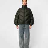 Dunjakke med høj hals i 100% genanvendt polyester. Tetrismd jacket har en lynlåslukning og en justerbar elastik i ærmet. Modellen er 175 cm og har en str. s/36 på.