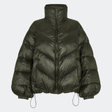Dunjakke med høj hals i 100% genanvendt polyester. Tetrismd jacket har en lynlåslukning og en justerbar elastik i ærmet. Modellen er 175 cm og har en str. s/36 på.