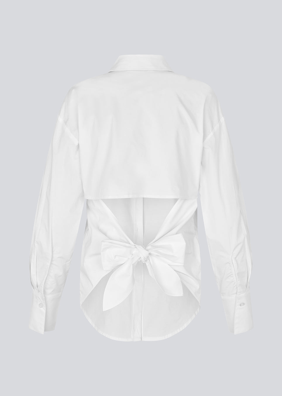 Figursyet hvid skjorte med åben ryg med bindedetalje. Thememd shirt har en skjortekrave og en knappelukning fortil. Modellen er 175 cm og har en str. S/36 på.

Materiale:
97% Bomuld
3% Elastan