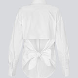 Figursyet hvid skjorte med åben ryg med bindedetalje. Thememd shirt har en skjortekrave og en knappelukning fortil. Modellen er 175 cm og har en str. S/36 på.

Materiale:
97% Bomuld
3% Elastan