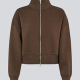 Sporty og moderne brun sweatshirt. Tiamd 2way zip cardigan er fremstillet i 50% bomuld og 50% polyester og designet med høj krave, tovejslynlås og en afslappet silhuet. En komfortabel garderobefavorit, der kombinerer et cool, sporty udtryk med alsidige stylingmuligheder.