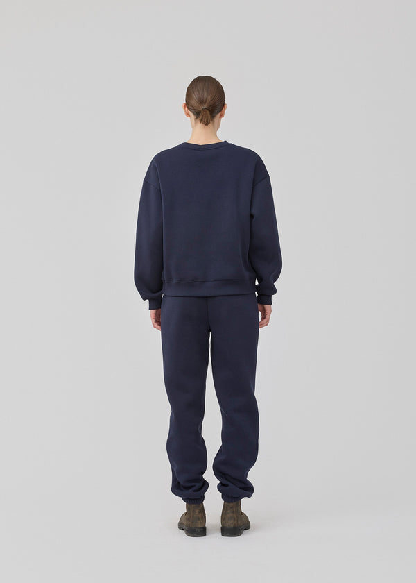 Sweatpants i mørkeblå i bomuldsblanding med logo. TiaMD pants har sidelommer, bindebånd og elastik i benene og taljen.
