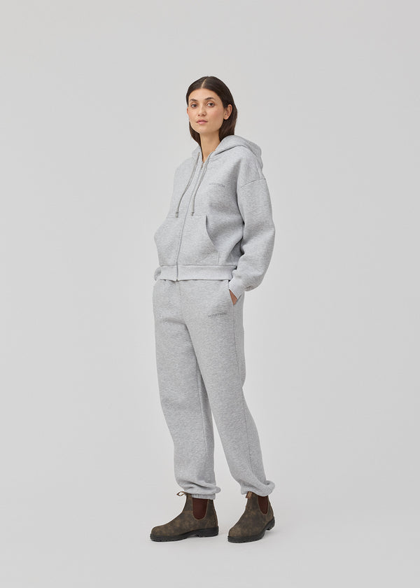 Sweatshirt i grå i bomuldsblanding med lynlås og logo. TiaMD zip har lommer, hætte med snørre og ribkant ved ærmer og bund.