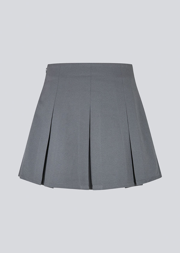 Kort grå nederdel med læg i struktureret materiale. TianaMD skirt har en usynlig lynlås i siden.