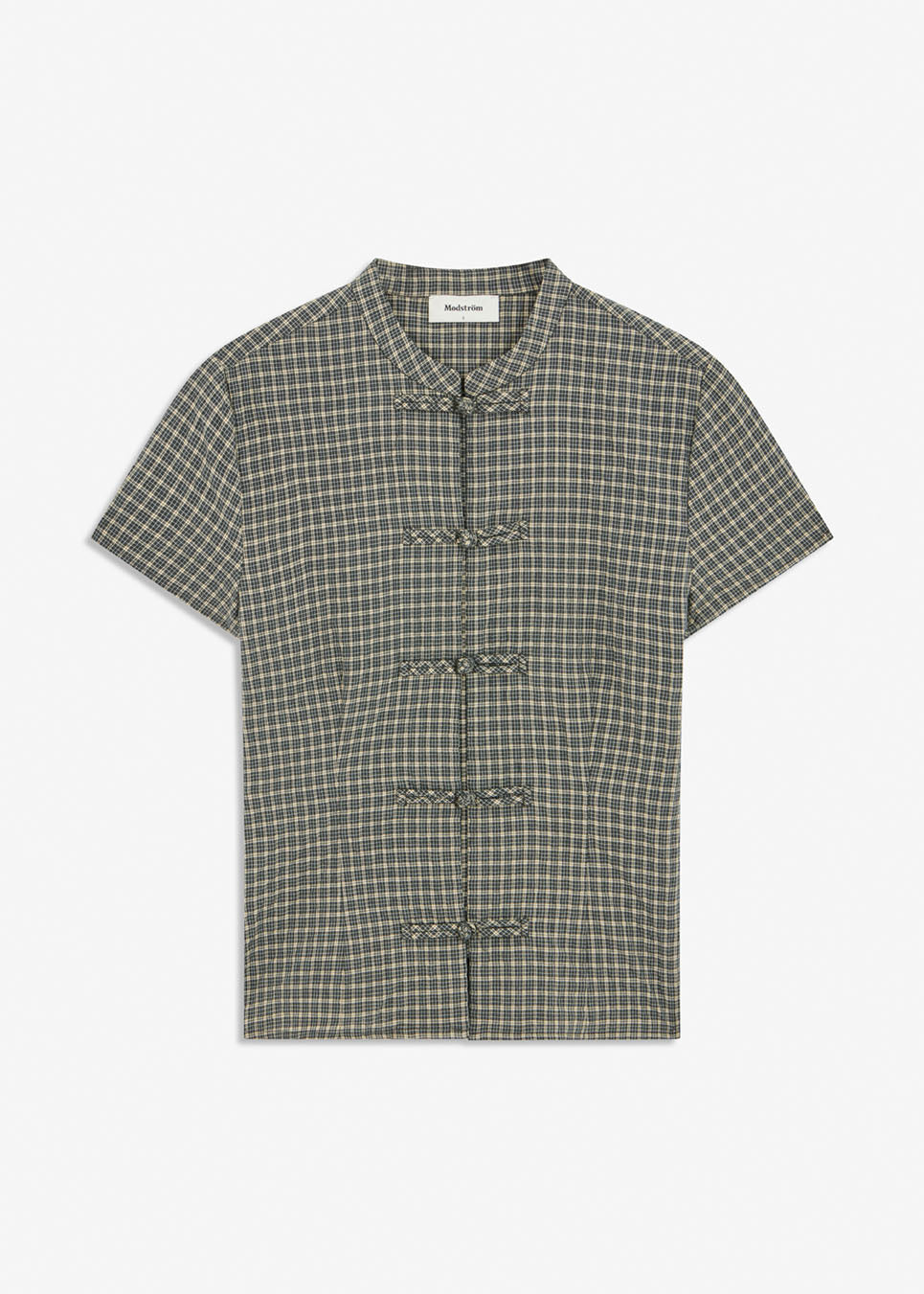 TikkaMD Top er en kortærmet top med løs pasform og klassisk ternet mønster. Designet har rund hals og dekorative knaplukninger foran. Style den med jeans eller matchende tern for et komplet look.