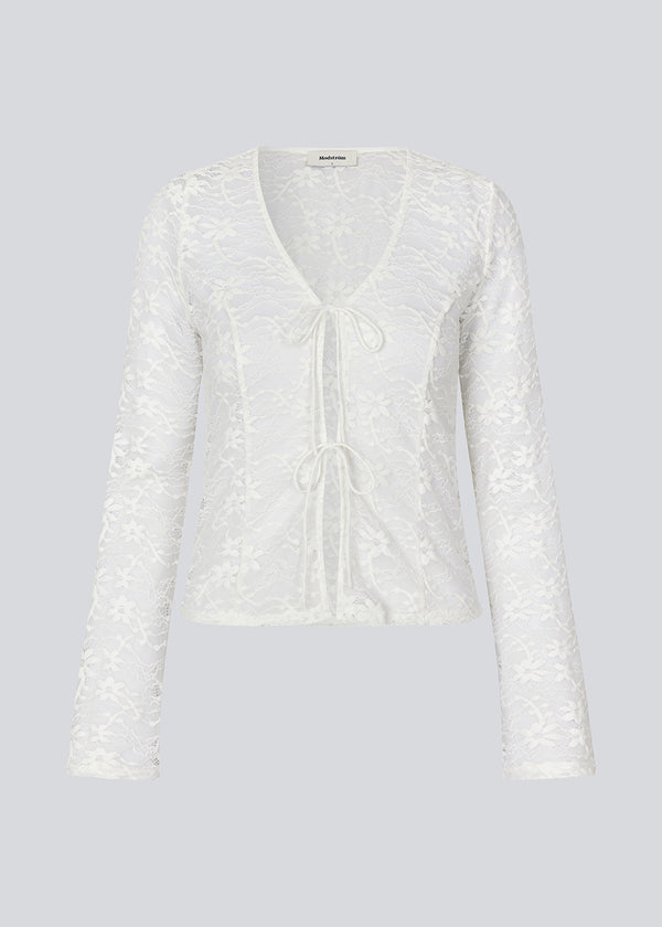 Figursyet top i hvid stretchy blonde med ærmer, der bliver bredere forneden. TildeMD lace top har en dyb V-udskæring og to bindebånd foran.