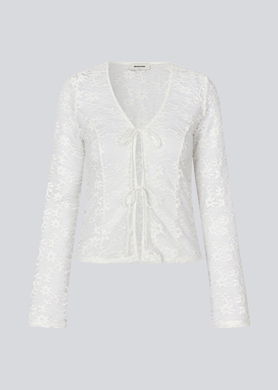 Figursyet top i hvid stretchy blonde med ærmer, der bliver bredere forneden. TildeMD lace top har en dyb V-udskæring og to bindebånd foran.