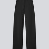 Loose black trousers with wide legs and a relaxed fit. Featuring an elastic waistband with drawstring for a comfortable, adjustable waist. White side stripes add a sporty and modern touch to the otherwise classic design. Perfect for casual everyday wear or more elevated styling – easy to pair with everything from t-shirts to dressy tops.