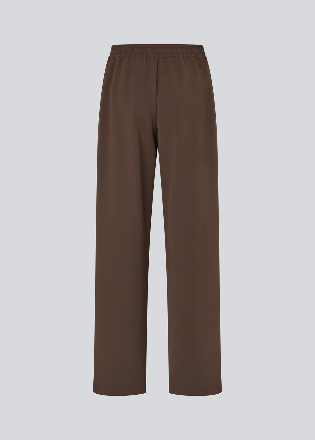 Løse brune bukser med bred benvidde og afslappet pasform. Bukserne har elastisk linning med snøre, der sikrer en behagelig og justerbar talje. Langs siderne løber hvide striber, som tilføjer et sporty og moderne twist til det ellers klassiske design. Perfekte til både afslappet hverdagsbrug og mere stilfulde outfits – nemme at style med alt fra t-shirts til skjorter.