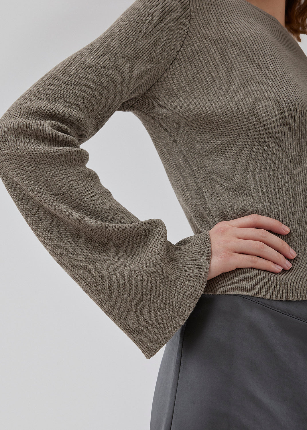 Finstrikket beige trøje i draperende kvalitet i glitrende materiale. TomMD o-neck har en let cropped længde med lange ærmer, der bliver bredere forneden. Rib ved halsudskæring og forneden. 