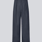 Habitbukser i twill med vide ben i mørkeblå. ToreMD pants har en mellemhøj talje, lynlåsgylp og lægforoven, samt sidelommer og paspolerede baglommer.