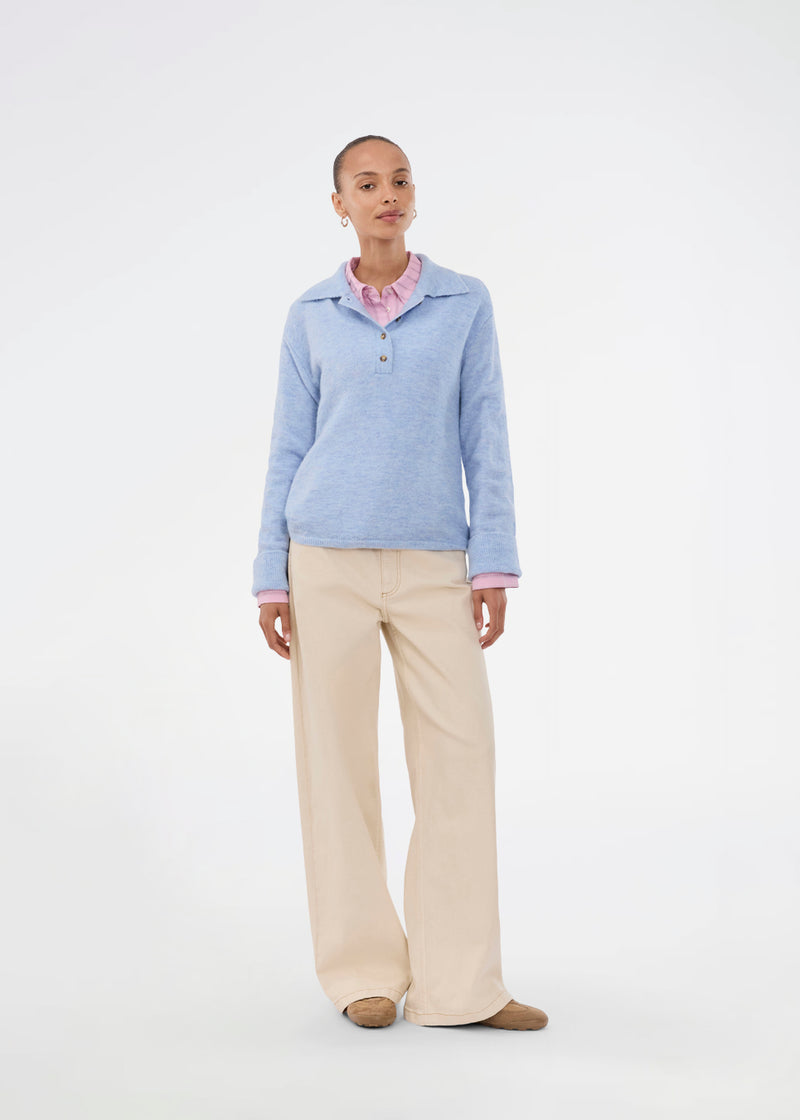 Strikket polo i blå med lange brede ærmer. Treemd polo har en stolpelukning og 4 knapper. Modellen er 175 cm og har en str. S/36 på.